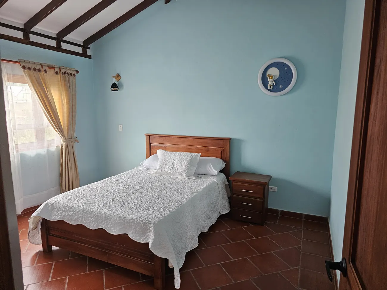 Habitación principal con cama doble y mecedora